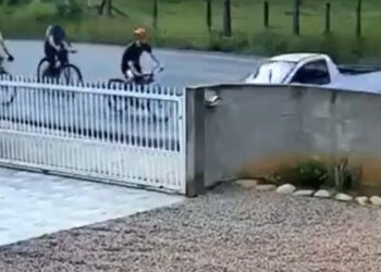 [Vídeo] Carro bate em ciclista e arranca portão de residência em SC